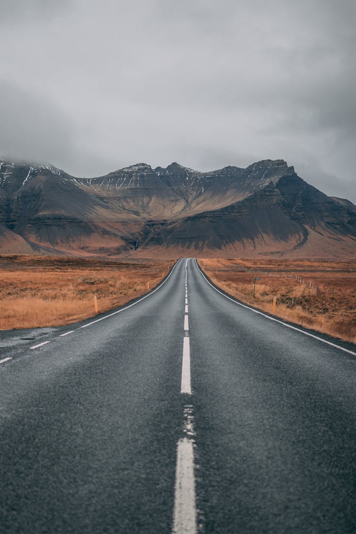 Crafting Captivating Headlines: Your awesome post title goes here A scenic empty road stretches into snow-capped mountains under cloudy skies, offering a sense of adventure and tranquility.